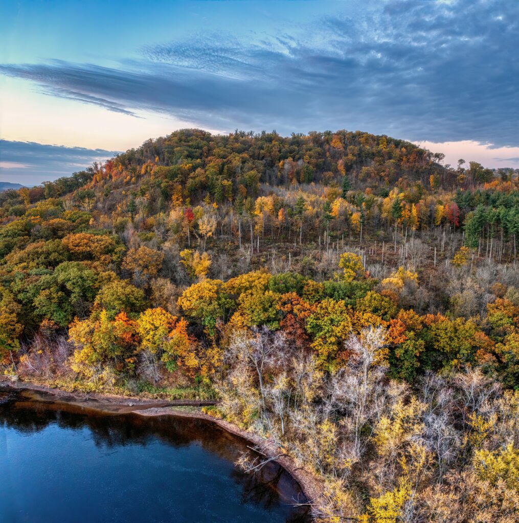 A stunning aerial shot capturing vibrant autumn foliage and a tranquil lake in Ella, Wisconsin.